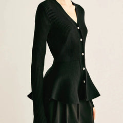 Black ribbed peplum knit top with metallic button detailing and fitted waist