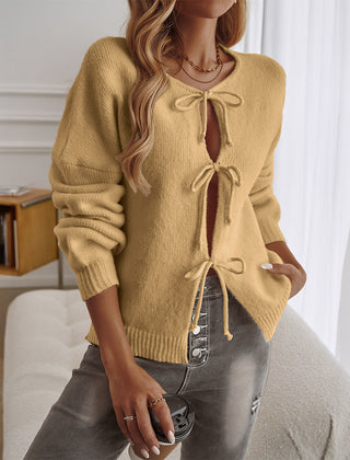 Woman wearing a soft knit tie front wrap cardigan with long sleeves and a cinched waist tie