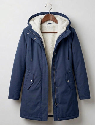 Woman wearing a cozy hooded longline weatherproof coat with plush lining and front pockets
