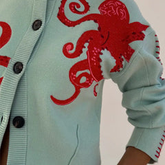 Light blue women's button-front cardigan with a bold octopus pattern across the front and sleeves