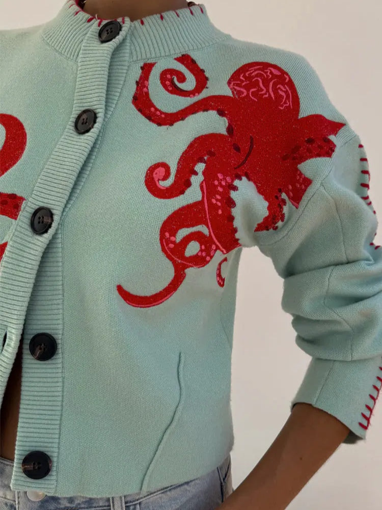 Light blue women's button-front cardigan with a bold octopus pattern across the front and sleeves