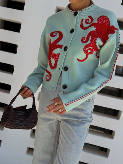 Light blue women's button-front cardigan with a bold octopus pattern across the front and sleeves