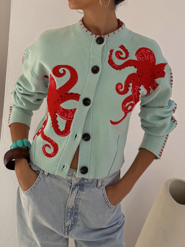Light blue women's button-front cardigan with a bold octopus pattern across the front and sleeves