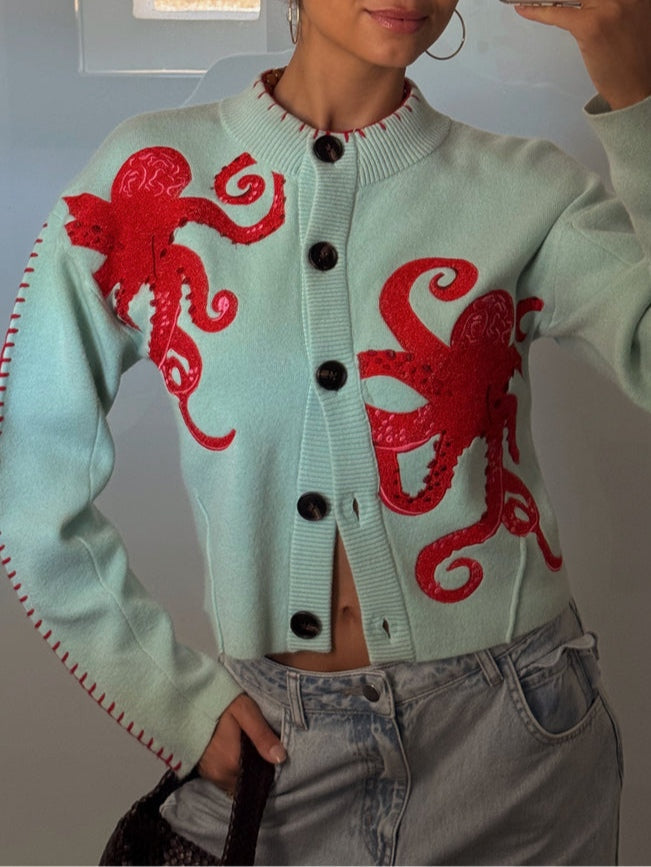 Light blue women's button-front cardigan with a bold octopus pattern across the front and sleeves
