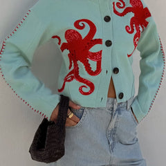 Light blue women's button-front cardigan with a bold octopus pattern across the front and sleeves