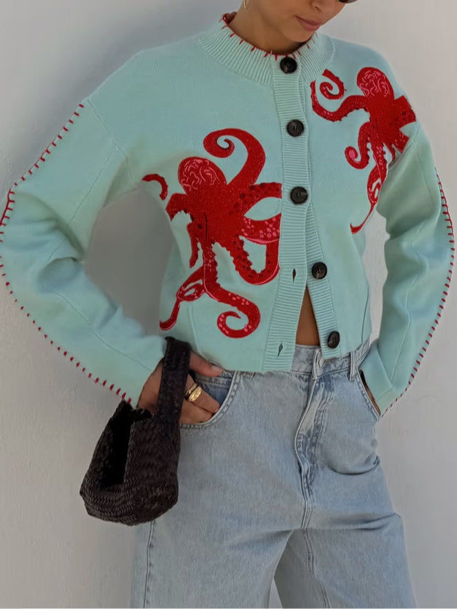 Light blue women's button-front cardigan with a bold octopus pattern across the front and sleeves