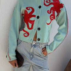 Light blue women's button-front cardigan with a bold octopus pattern across the front and sleeves