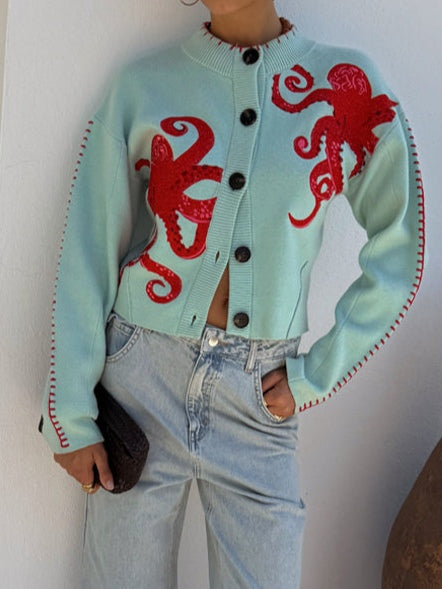 Light blue women's button-front cardigan with a bold octopus pattern across the front and sleeves
