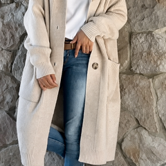 Woman wearing a long flowing knit cardigan in a neutral shade over a casual outfit