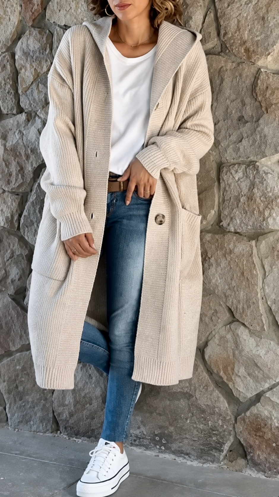 Woman wearing a long flowing knit cardigan in a neutral shade over a casual outfit