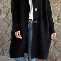 Woman wearing a long flowing knit cardigan in a neutral shade over a casual outfit