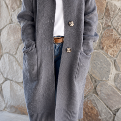 Woman wearing a long flowing knit cardigan in a neutral shade over a casual outfit