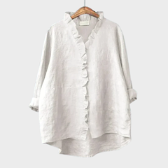 Woman wearing a feminine ruffle-trim blouse with a relaxed, gently draped fit