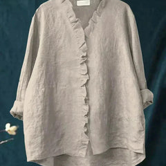 Woman wearing a feminine ruffle-trim blouse with a relaxed, gently draped fit