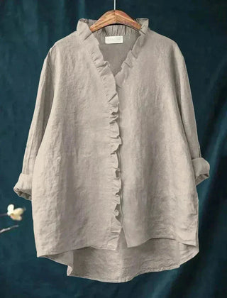 Woman wearing a feminine ruffle-trim blouse with a relaxed, gently draped fit