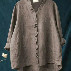Woman wearing a feminine ruffle-trim blouse with a relaxed, gently draped fit