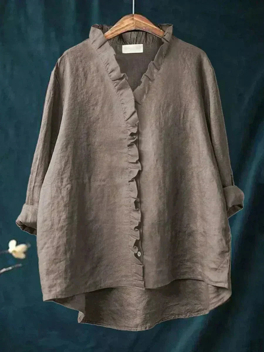 Woman wearing a feminine ruffle-trim blouse with a relaxed, gently draped fit