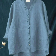 Woman wearing a feminine ruffle-trim blouse with a relaxed, gently draped fit