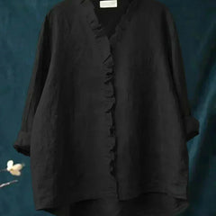 Woman wearing a feminine ruffle-trim blouse with a relaxed, gently draped fit