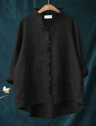 Woman wearing a feminine ruffle-trim blouse with a relaxed, gently draped fit