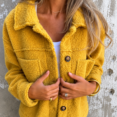 Woman wearing a soft fleece button-front jacket with lapel collar and side pockets