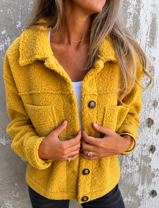 Woman wearing a soft fleece button-front jacket with lapel collar and side pockets