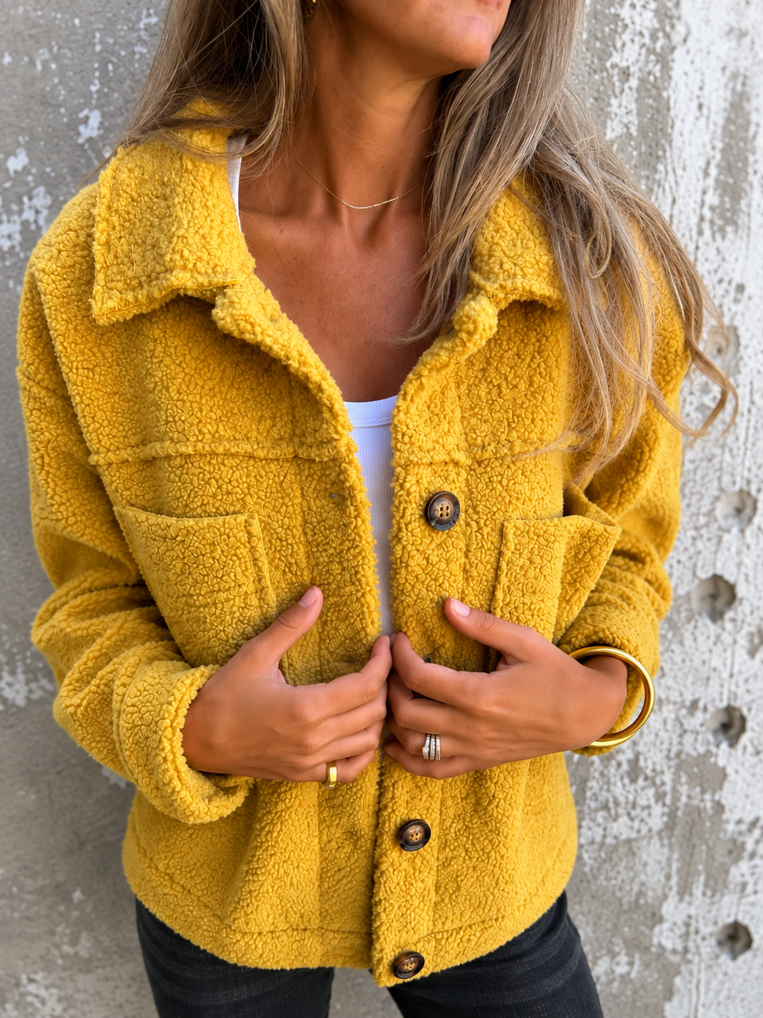 Woman wearing a soft fleece button-front jacket with lapel collar and side pockets