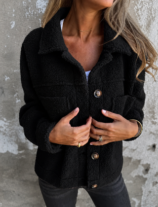 Woman wearing a soft fleece button-front jacket with lapel collar and side pockets