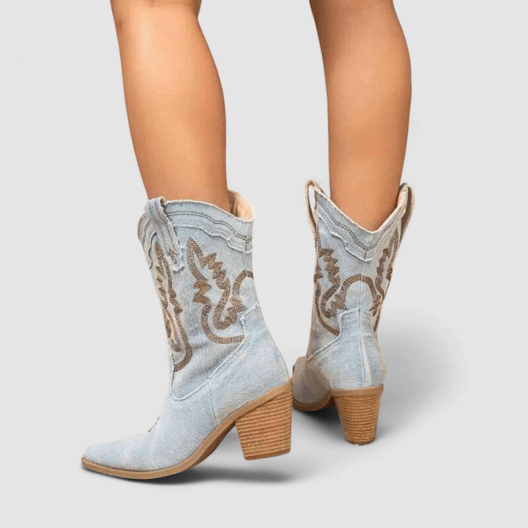 Embroidered western cowboy boots in faded blue with scrollwork shaft, pointed toe and block heel