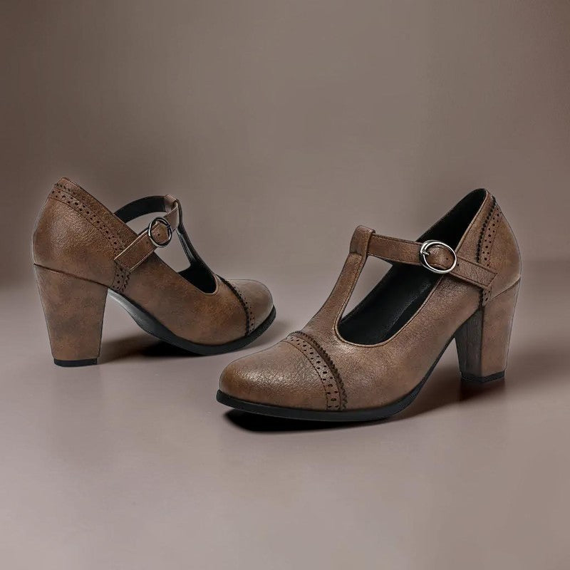T-strap brogue heels with punched detailing on a steady block heel, shown in a neutral tone