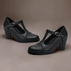 T-strap brogue heels with punched detailing on a steady block heel, shown in a neutral tone