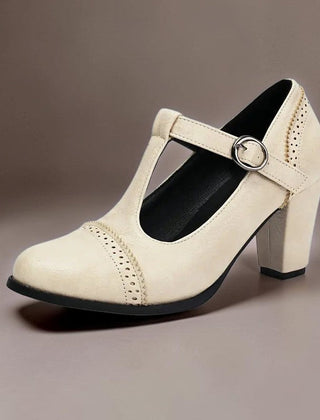 T-strap brogue heels with punched detailing on a steady block heel, shown in a neutral tone