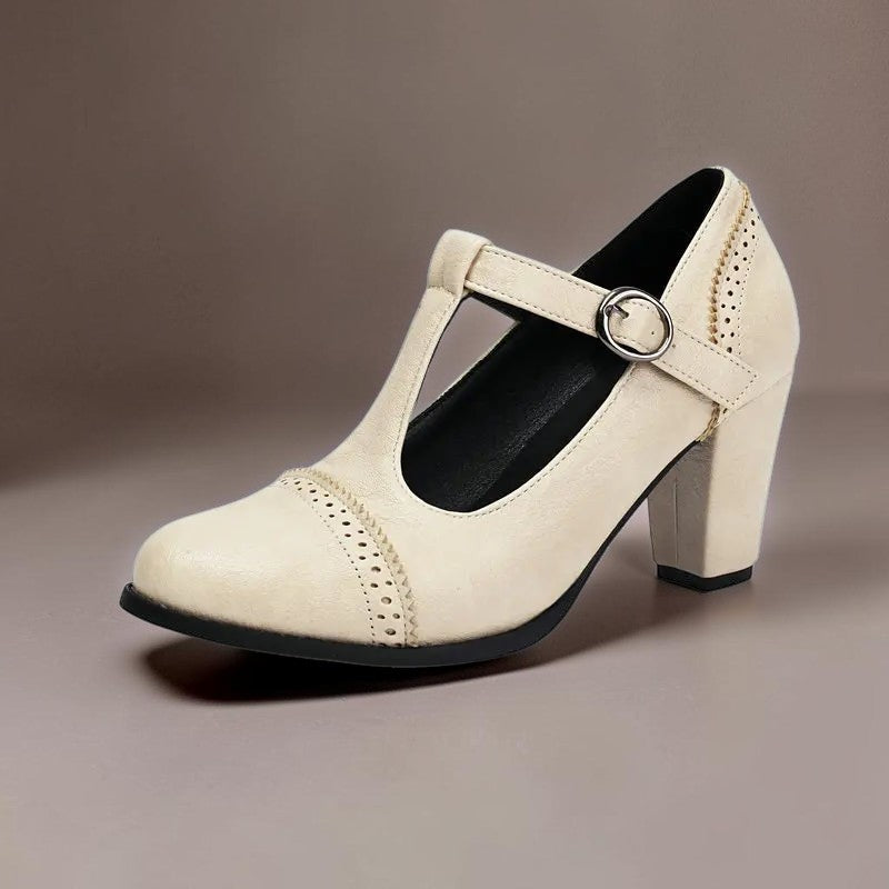 T-strap brogue heels with punched detailing on a steady block heel, shown in a neutral tone