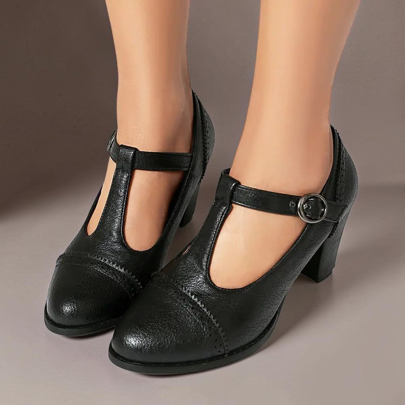 T-strap brogue heels with punched detailing on a steady block heel, shown in a neutral tone