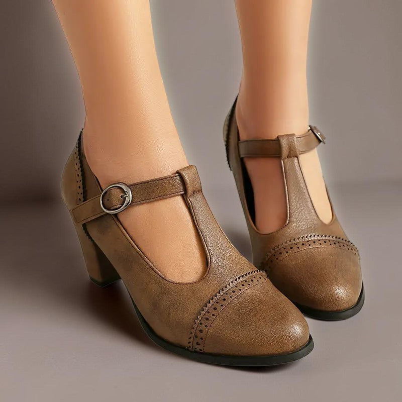 T-strap brogue heels with punched detailing on a steady block heel, shown in a neutral tone