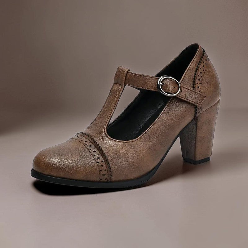 T-strap brogue heels with punched detailing on a steady block heel, shown in a neutral tone